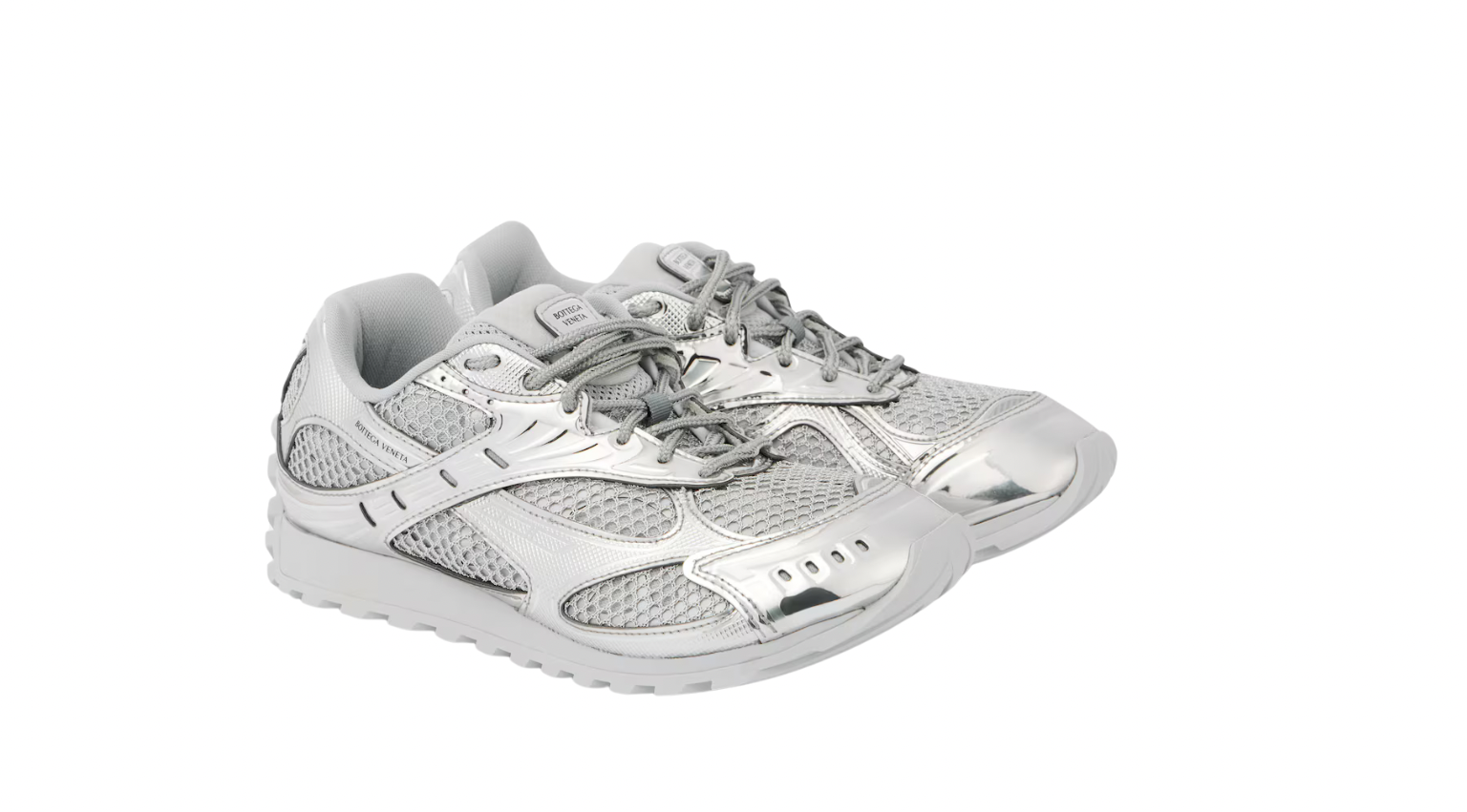 Silver and grey athletic sneakers with mesh and metallic details, featuring laces and a white sole, displayed from the front.