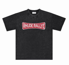 Black short-sleeve t-shirt with a faded wash and bold red "RHUDE RALLYE" graphic across the chest in a vintage-style curved banner.