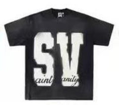 A black Saint Vanity t-shirt featuring large "SV" letters on the front with "saint vanity" text underneath in a smaller font.