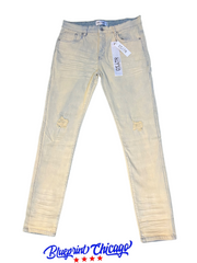 Light-washed distressed denim jeans with rips, featuring a tag and Blueprint Chicago logo at the bottom.