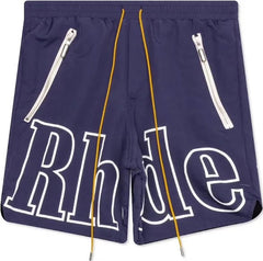 Navy blue Rhude shorts with bold white outlined logo across front, yellow drawstrings, and two slanted zippered pockets with silver pulls.