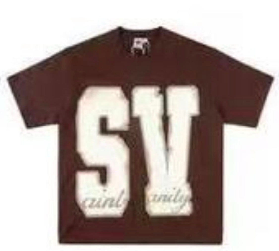 A brown Saint Vanity t-shirt with large "SV" lettering on the front and "saint vanity" text in a smaller font below.