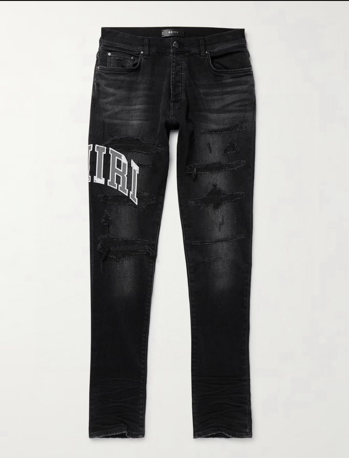 Black distressed slim-fit jeans with rips and white "AMIRI" text on the left thigh, featuring front and back pockets.