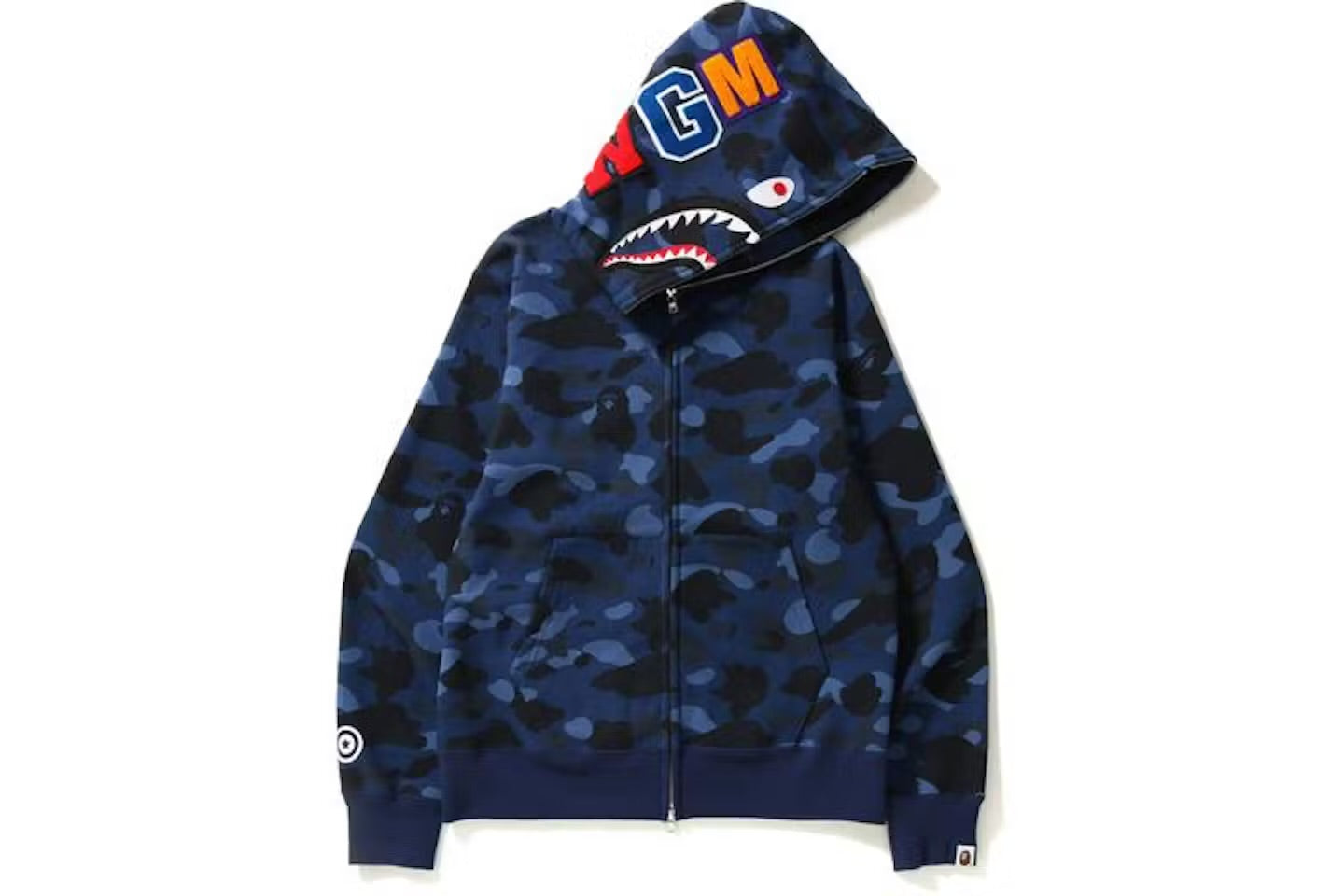 A blue camouflage BAPE zip-up hoodie featuring a shark face graphic on the hood with colorful lettering and a logo on the sleeve.