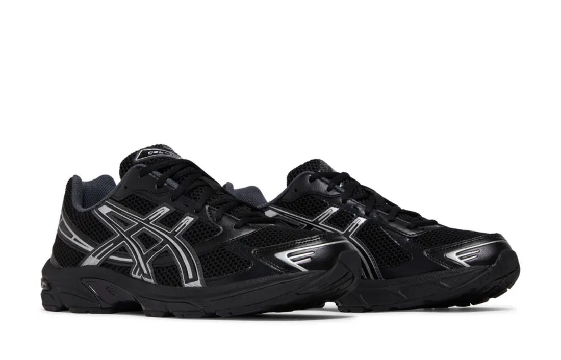 A pair of black and silver ASICS sneakers with mesh uppers, reflective detailing, and a cushioned sole for comfort and performance.
