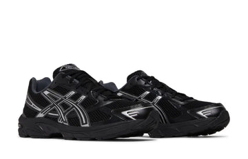 A pair of black and silver ASICS sneakers with mesh uppers, reflective detailing, and a cushioned sole for comfort and performance.