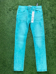 A pair of bright turquoise skinny jeans with a faded look, hanging with price tags still attached.