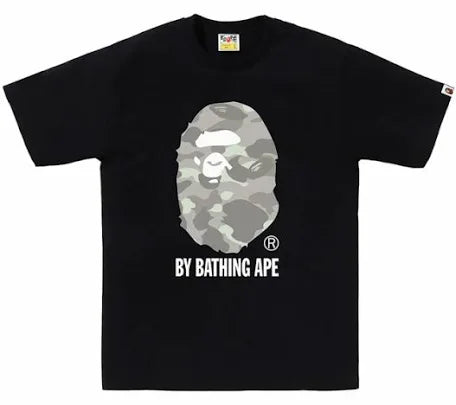 A black t-shirt featuring the BAPE logo, with a camouflage ape face design and the text "BY BATHING APE" underneath.