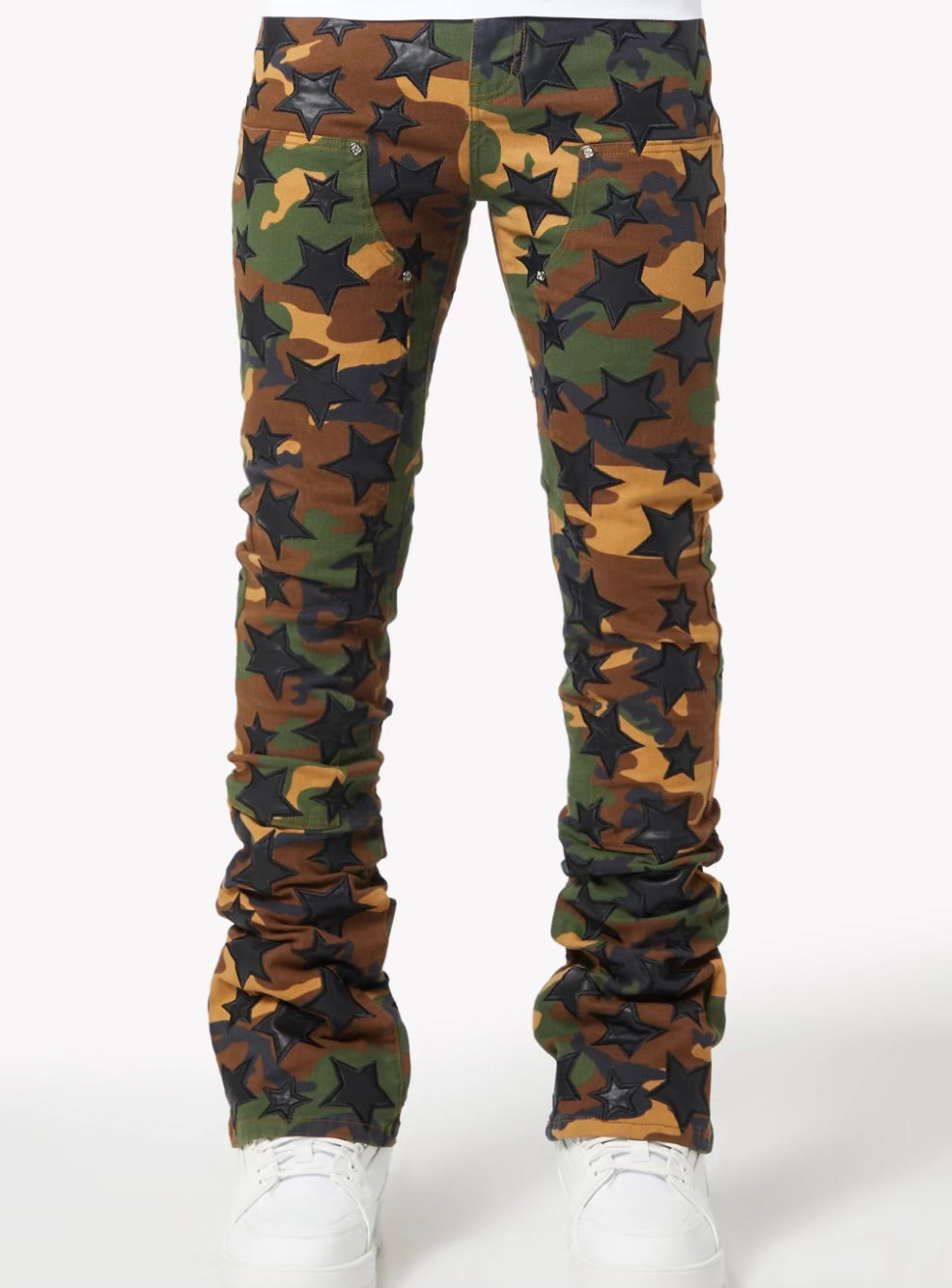 Camouflage pants decorated with black stars in various sizes worn with white sneakers on a plain white background.