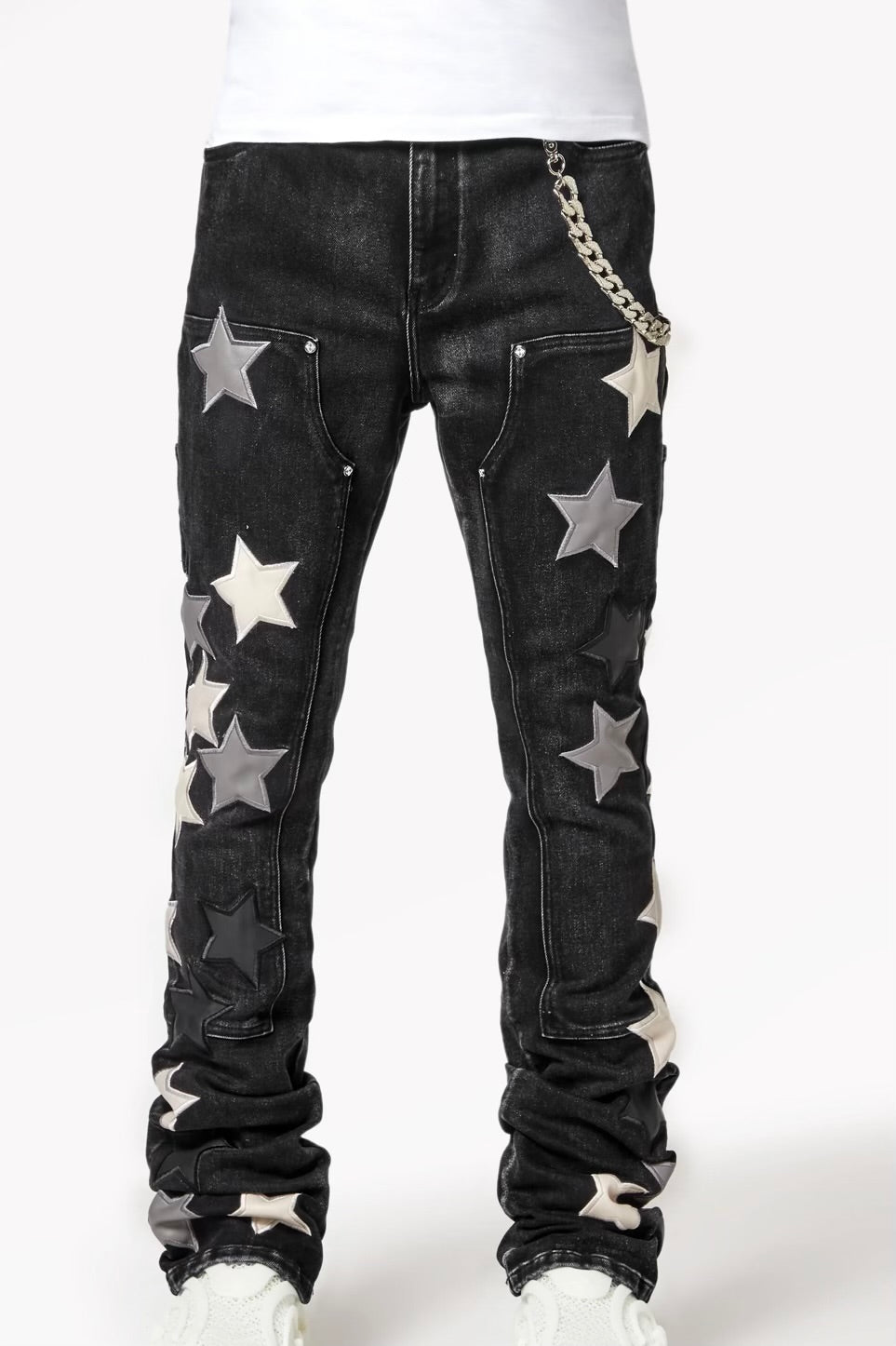 Black jeans with large star-shaped patches in shades of gray and silver, accompanied by a chain accessory on the side.