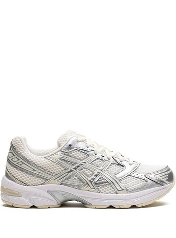 A side view of a white and silver ASICS running shoe with mesh detailing, a cushioned sole, and the brand's logo on the side.