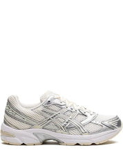 A side view of a white and silver ASICS running shoe with mesh detailing, a cushioned sole, and the brand's logo on the side.