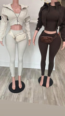 Two mannequins showcasing matching outfits: a white cropped zip-up jacket with leggings and a brown zip-up jacket with leggings.