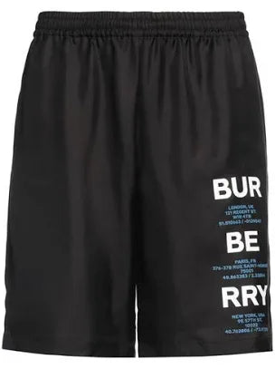 A pair of black shorts with "BURBERRY" branding and various city coordinates printed in blue text along the side.