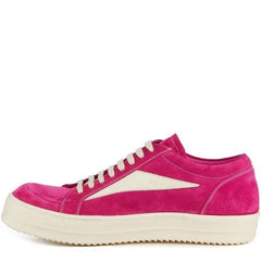Bright pink suede sneakers with beige accents and white stitching, featuring a low-profile design and cream-colored sole, displayed from the side.