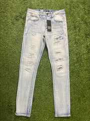 A pair of light-wash ripped skinny jeans with distressed details on the front, featuring a tag attached to the waistband.