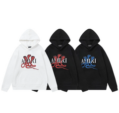 Three AMIRI hoodies in white and black with a cobra snake graphic in red and blue, and "AMIRI" logo across the chest.