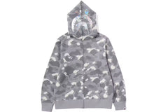 A gray camouflage BAPE hoodie with a shark face graphic on the hood, featuring a zipper and front pockets.