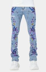 Front view of blue denim jeans with colorful purple and blue floral embroidery worn with white sneakers on a plain white background.
