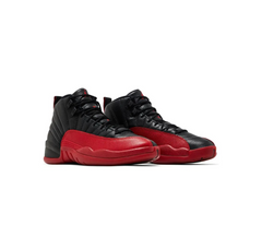 Black and red basketball shoes with textured leather, black laces, and a low profile, displayed on a white background.