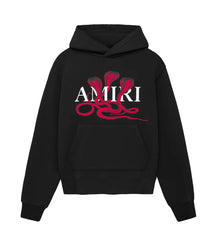 Black hoodie with front pocket featuring three red cobras and the white "AMIRI" text logo centered on the chest area.