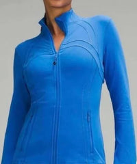 Bright blue long-sleeve zip-up jacket with high collar, front zip, zippered side pockets, and curved seam design on torso.