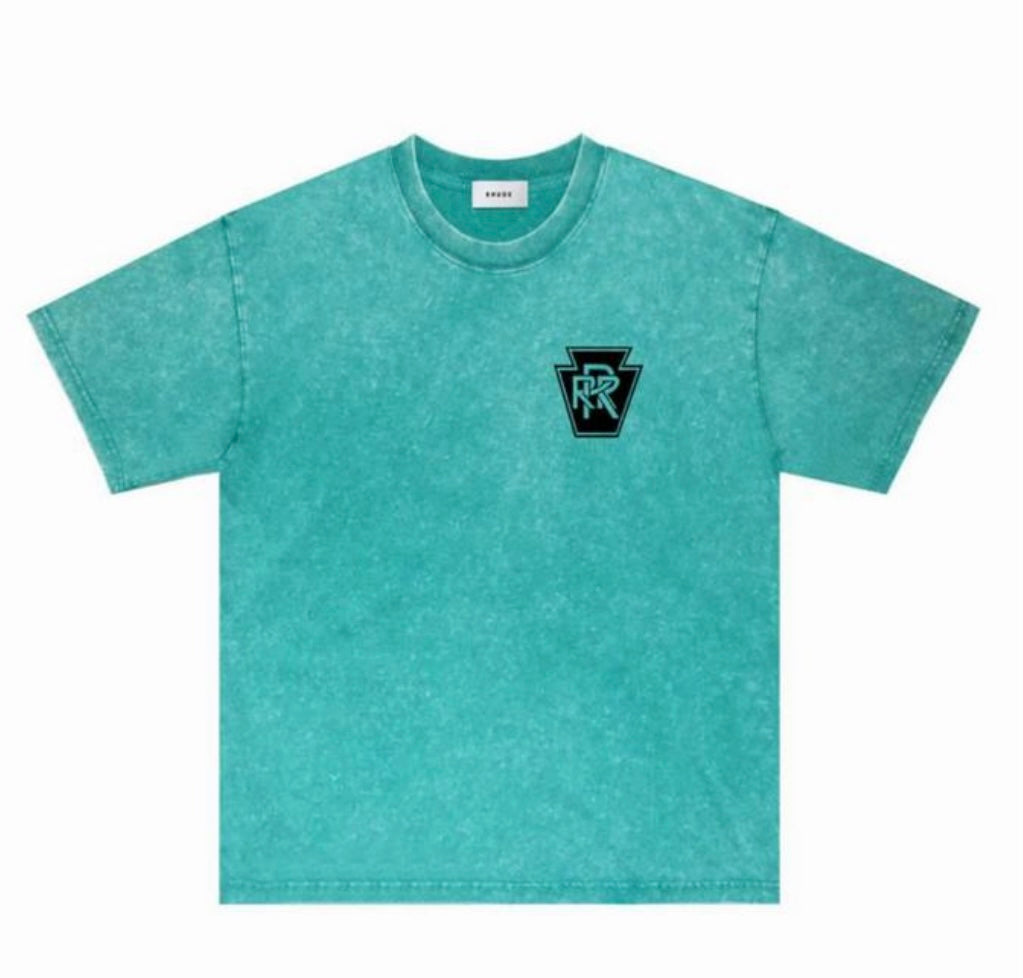 Turquoise washed short sleeve t-shirt with small black and turquoise logo on left chest, laid flat on white background.