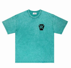 Turquoise washed short sleeve t-shirt with small black and turquoise logo on left chest, laid flat on white background.