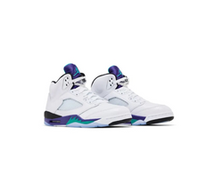 A pair of white Air Jordan 5 sneakers with purple, teal, and black accents on the sole and upper, featuring a mesh panel.
