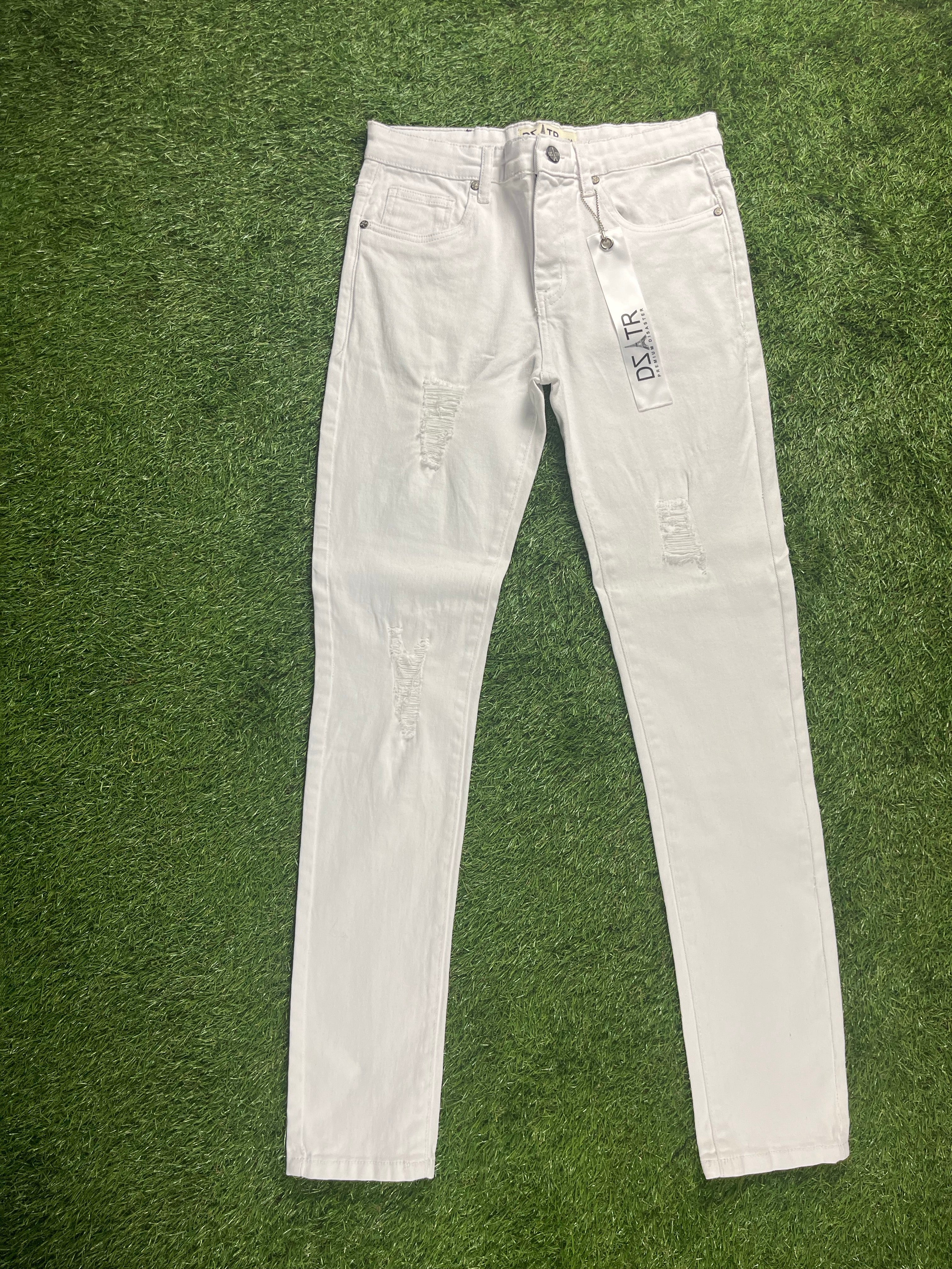 A pair of white skinny jeans with distressed detailing on the front, featuring tags attached to the waistband.