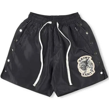 A pair of black Saint Laurent shorts with side snap buttons, an elastic waistband, and a patch logo on the front.