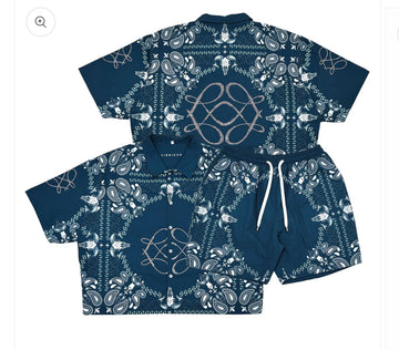 A blue matching shirt and shorts set featuring intricate white paisley and skull designs with a drawstring on the shorts.