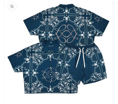 A blue matching shirt and shorts set featuring intricate white paisley and skull designs with a drawstring on the shorts.