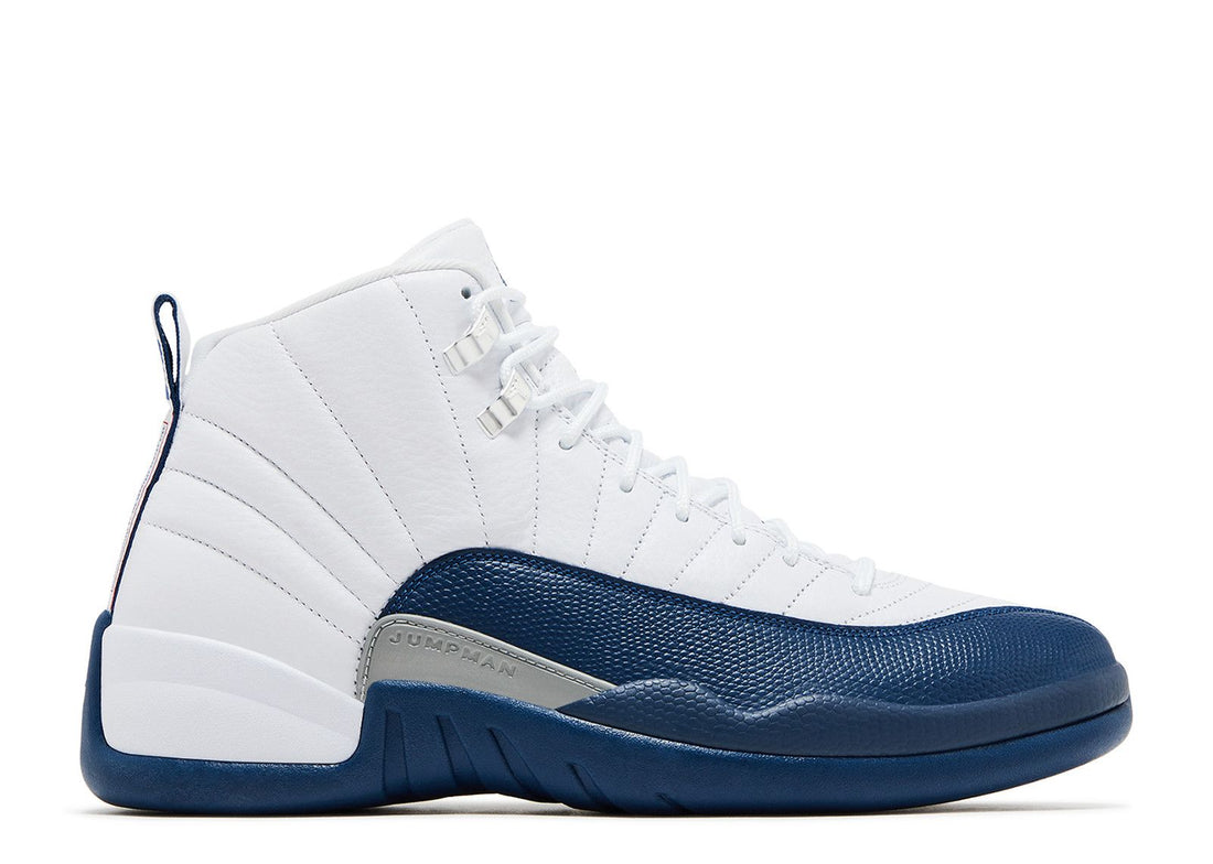 A pair of white and navy blue Air Jordan 12 sneakers with a textured leather design and the "JUMPMAN" logo on the side.