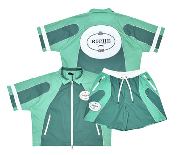 Mint green and dark teal short sleeve zip jacket with matching shorts, featuring white RICHE logos and zippered pockets.
