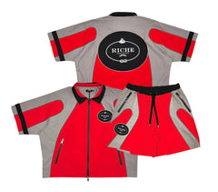 A red and grey tracksuit set, featuring a zip-up jacket with a "Riche" logo on the back and matching shorts with similar detailing.