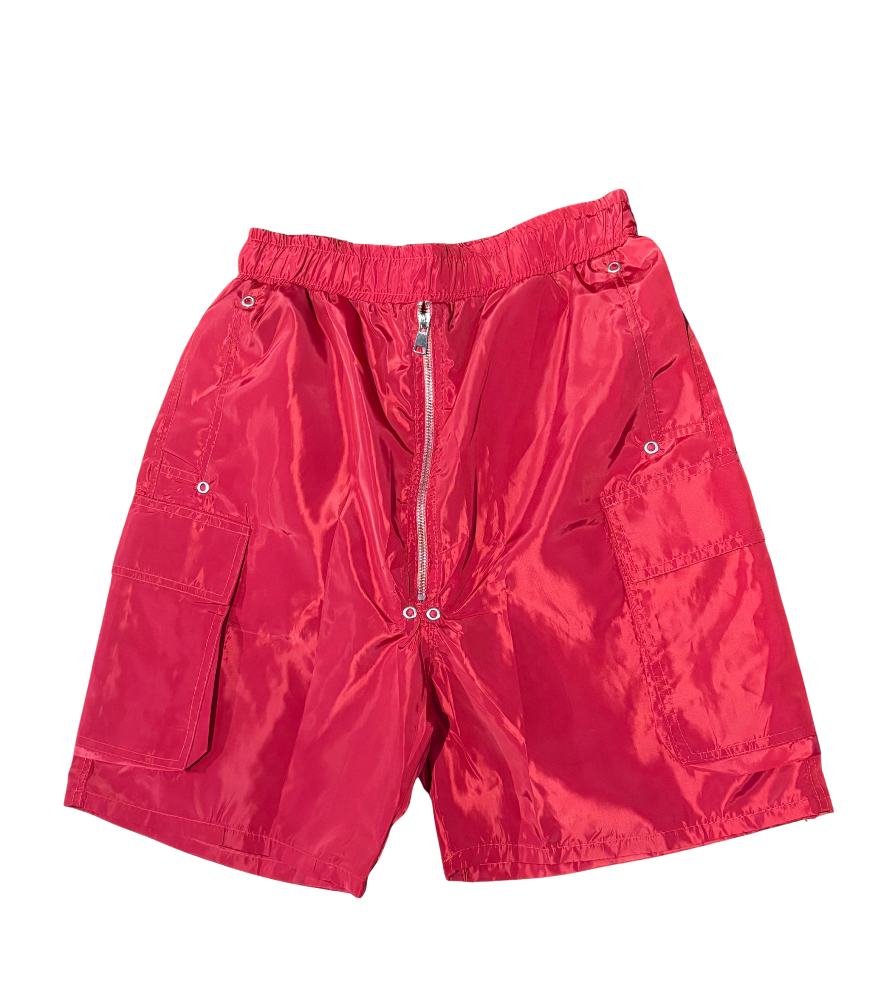 Bright red shiny nylon shorts with elastic waistband, silver zipper front, and large flap pockets on each side against white.