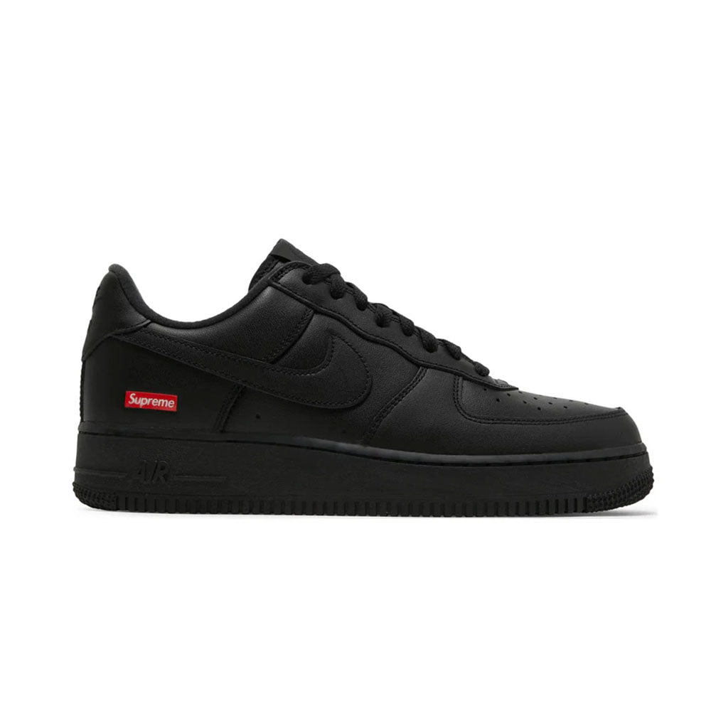 A side view of a black Nike Air Force 1 sneaker featuring a leather upper and a red Supreme logo on the side near the heel.